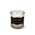 Candle in a glass container with 'The Lost Wax Company' branding on a white background
