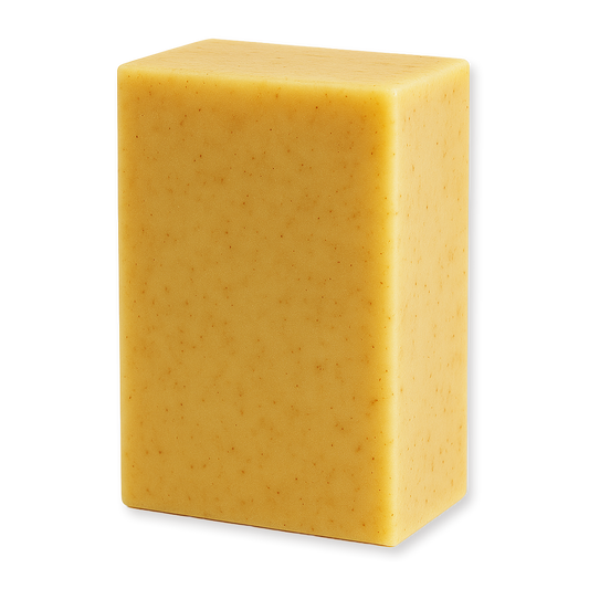 A rectangular bar of handmade soap in a warm golden yellow color with tiny brown specks, shown on a plain white background.