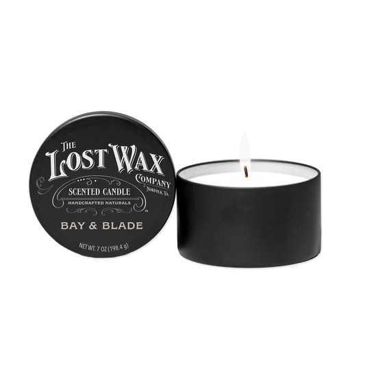 Scented candle with 'Bay & Blade' label and lid from 'The Lost Wax Company' on a white background