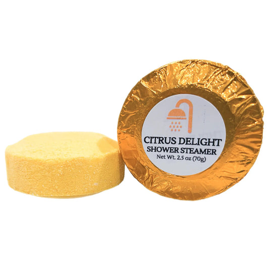 Yellow "Citrus Delight" Shower Steamer package next to an unwrapped steamer.
