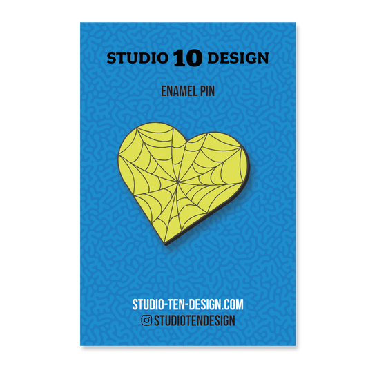 Yellow heart-shaped spider web design on a blue card with 'Studio 10 Design' text.