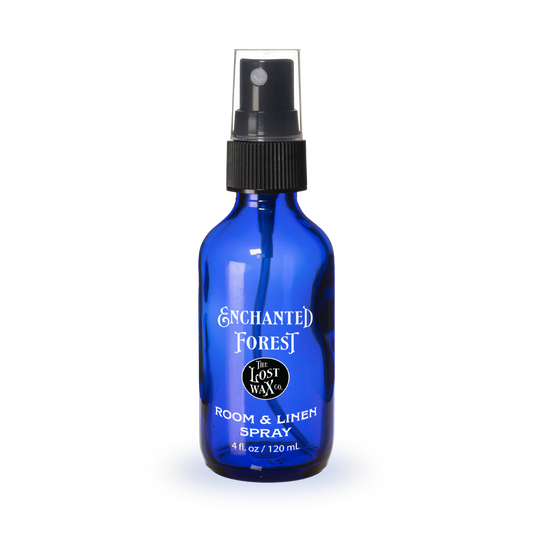Blue spray bottle labeled 'Enchanted Forest' on a white background