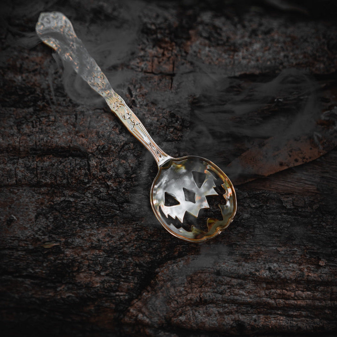 Silver Halloween Tea Spoon, on a rough wood background