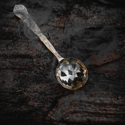 Silver Halloween Tea Spoon, on a rough wood background