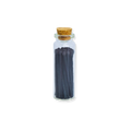 Small glass bottle with cork lid containing dark sticks on a white background