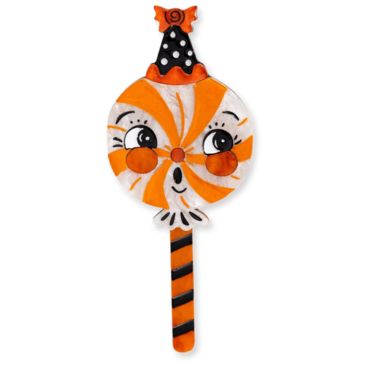 A decorative Halloween-themed brooch featuring a cartoon cat face with orange and white swirls, black polka-dot ears, and an orange-and-black striped stick, shown on a plain white background.