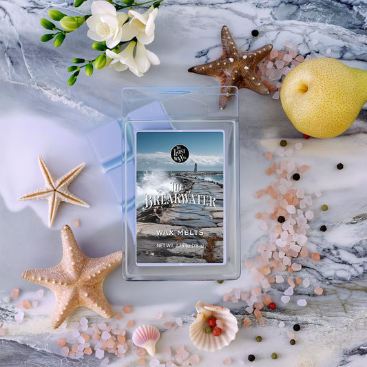 Wax melt packaging with starfish, pear, sea salt, peppercorns, freesia flowers, and seashells on a decorative background